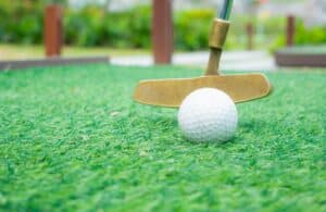 Golf putting practice on artificial green grass.