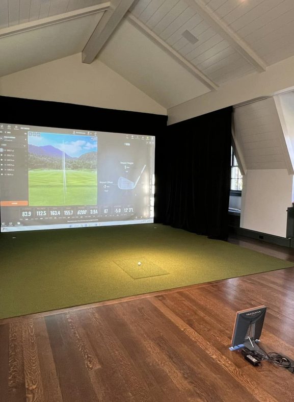 Close-up of a golf simulator monitor displaying a golf course